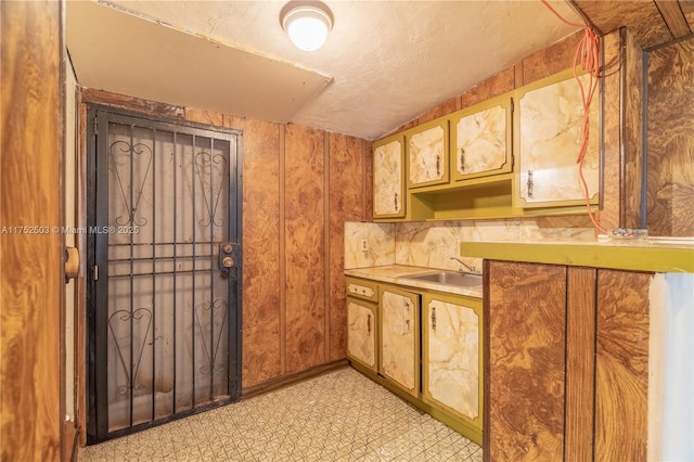 kitchen with light countertops, light floors, a sink, and brown cabinets