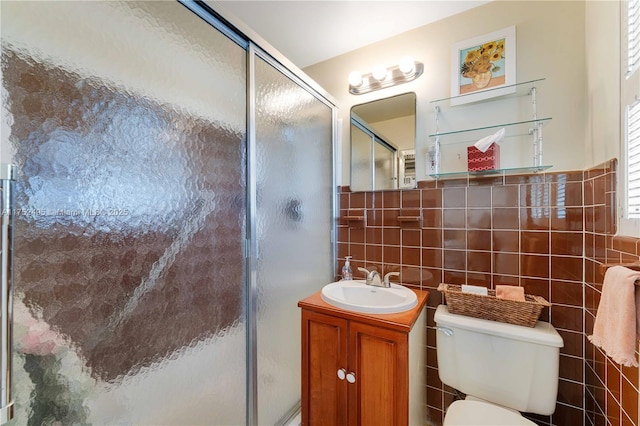 full bath with toilet, a stall shower, tile walls, and vanity