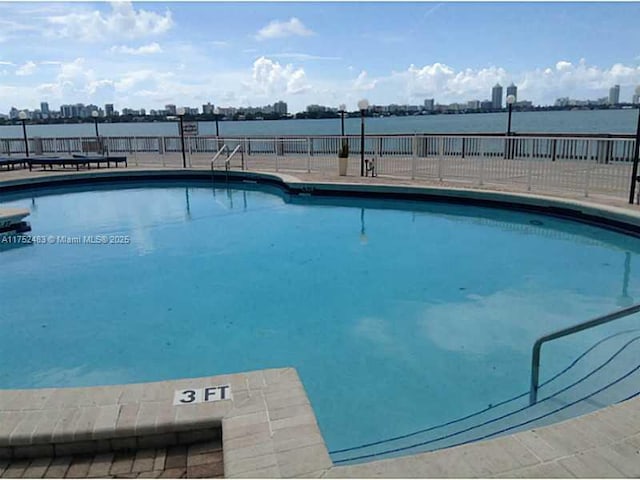 pool featuring fence and a city view