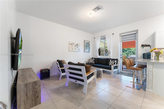 living area featuring light tile patterned floors and visible vents