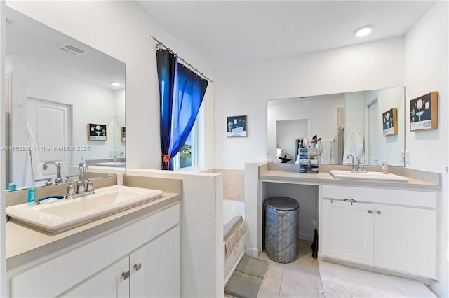 full bath featuring visible vents, a sink, a garden tub, tile patterned flooring, and two vanities