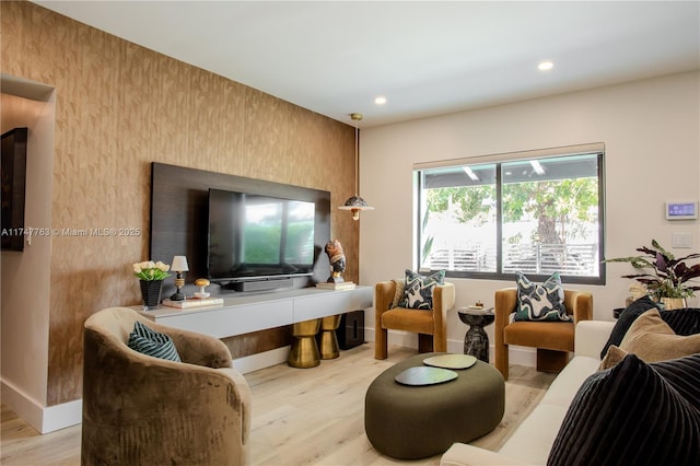 living room featuring light wood-type flooring, baseboards, and recessed lighting