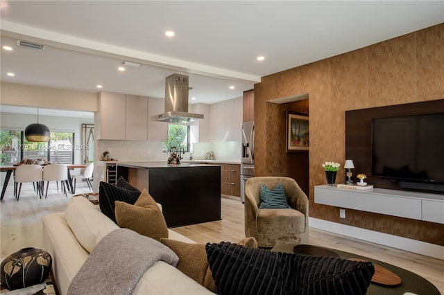 living area featuring a healthy amount of sunlight, light wood-style floors, and visible vents