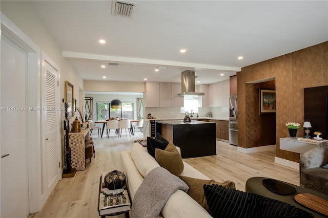 living area with light wood-style flooring, visible vents, and recessed lighting