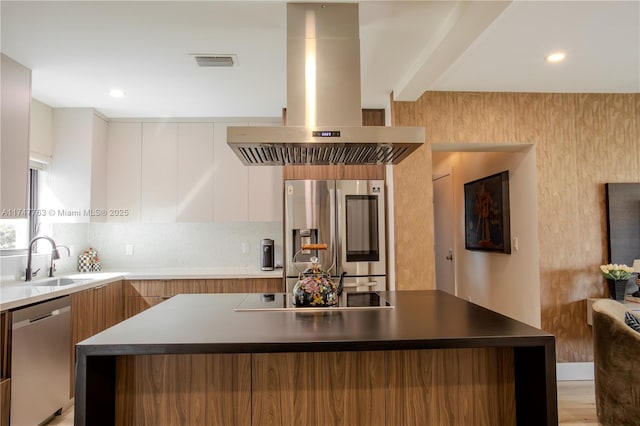 kitchen with a sink, appliances with stainless steel finishes, island exhaust hood, and white cabinets