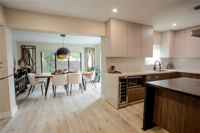 kitchen featuring tasteful backsplash, wine cooler, decorative light fixtures, and modern cabinets