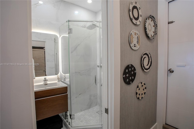 bathroom with a marble finish shower and vanity