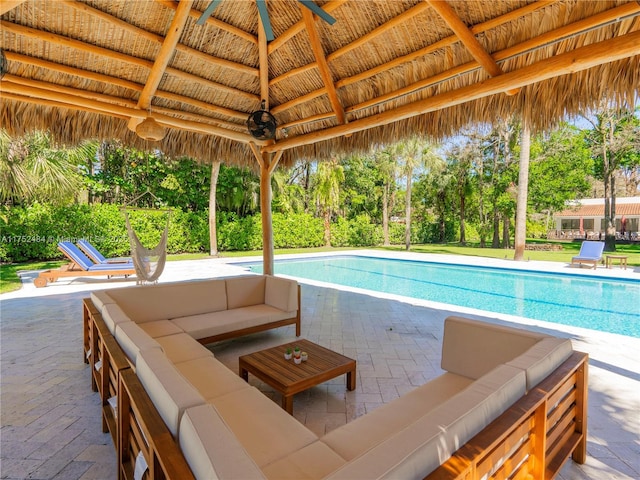 pool featuring a gazebo, a patio, an outdoor living space, and a ceiling fan