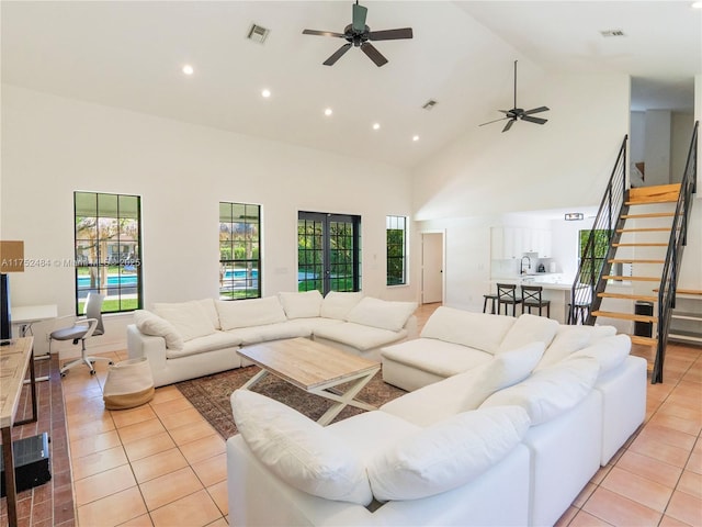 living room with high vaulted ceiling, light tile patterned flooring, and visible vents