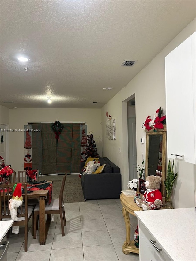 dining room with visible vents, light tile patterned flooring, and a textured ceiling