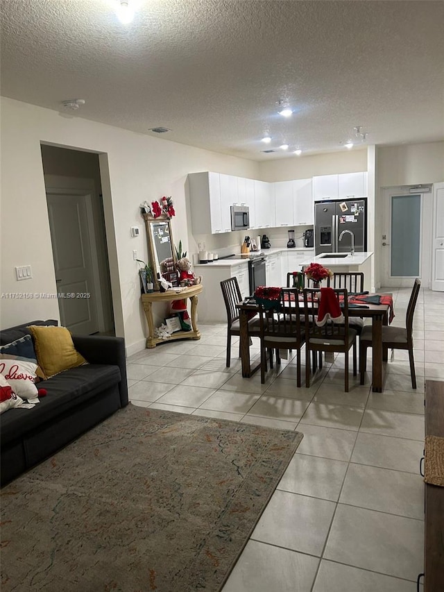 dining space with light tile patterned floors, visible vents, and a textured ceiling