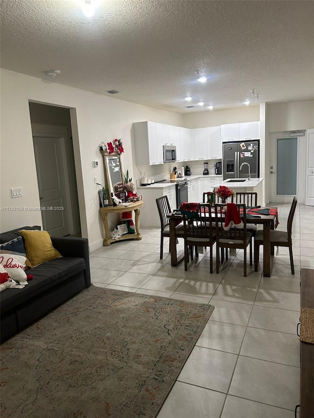 dining room with a textured ceiling, light tile patterned flooring, and visible vents