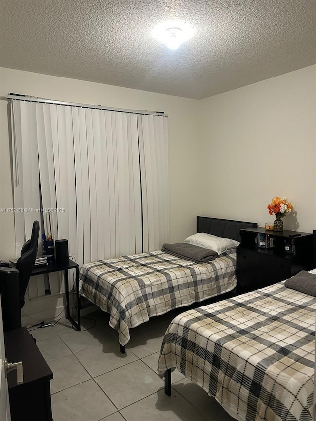 bedroom with light tile patterned floors and a textured ceiling