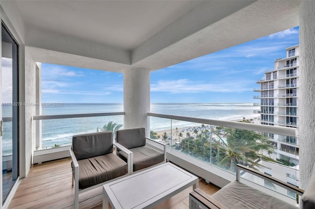 balcony featuring a beach view and a water view