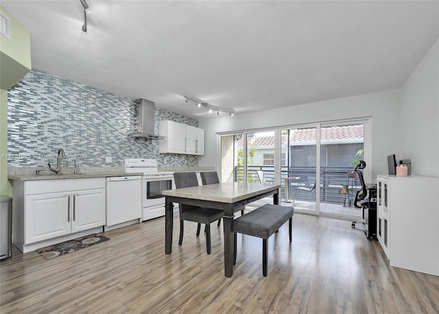 dining room featuring light wood-type flooring, rail lighting, and a textured ceiling