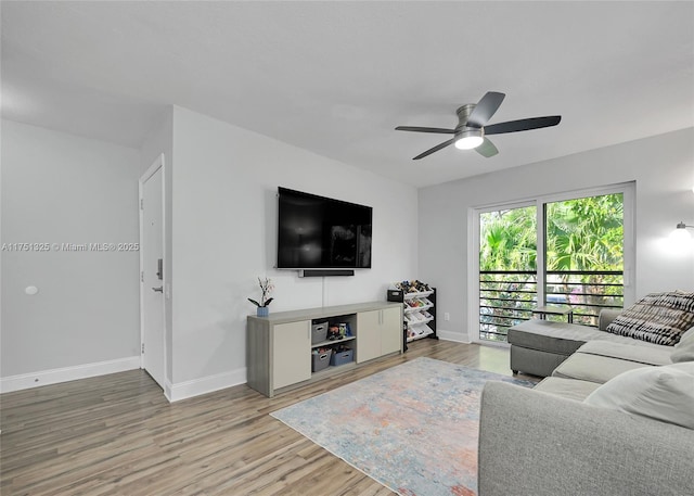 living room featuring ceiling fan, baseboards, and wood finished floors