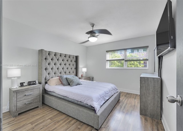 bedroom featuring a ceiling fan, light wood-style flooring, and baseboards