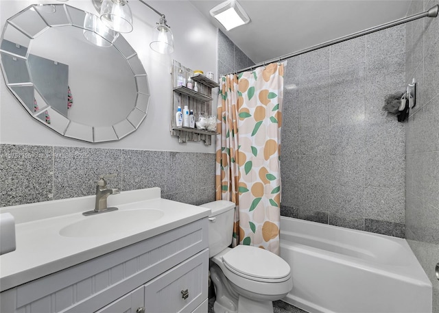 full bath featuring shower / bath combo, toilet, a wainscoted wall, vanity, and tile walls