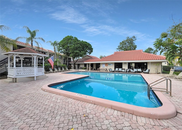 community pool with a patio area and a gazebo