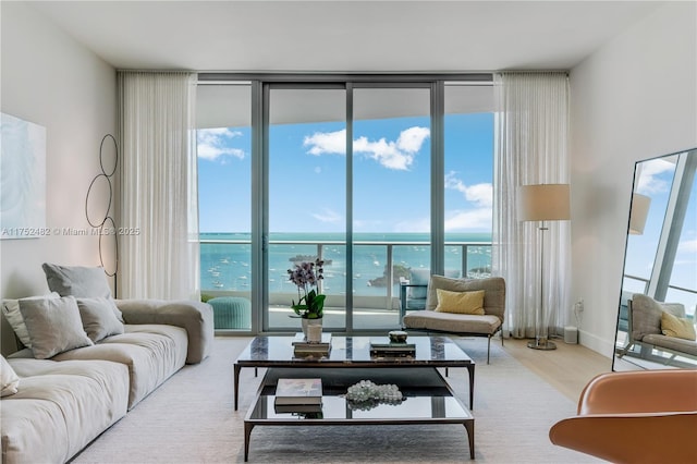 living room featuring a wall of windows, a water view, and wood finished floors