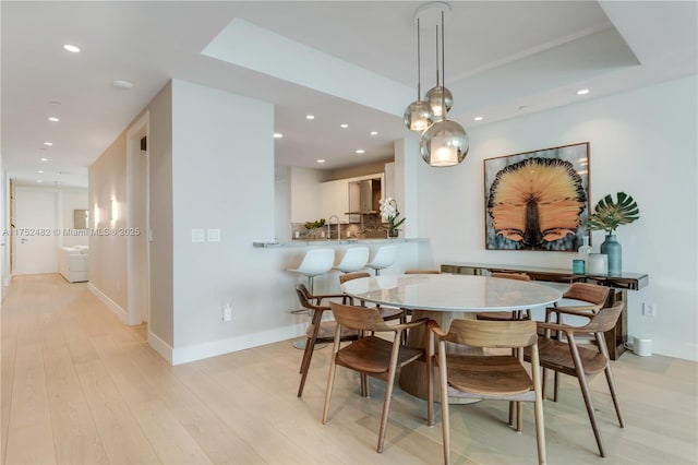 dining space featuring baseboards, light wood-style floors, and recessed lighting