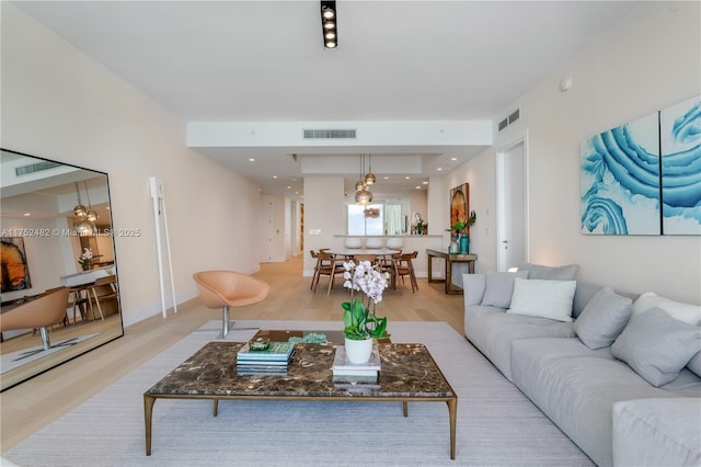 living room featuring baseboards, recessed lighting, visible vents, and light wood-style floors