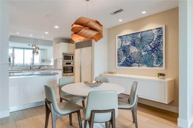 dining space with light wood finished floors, baseboards, visible vents, and recessed lighting