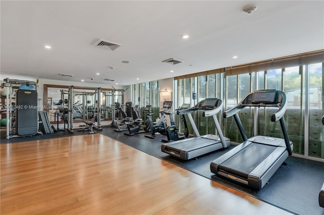 gym with wood finished floors, visible vents, and recessed lighting