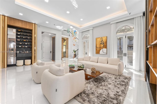 living area featuring french doors and a raised ceiling