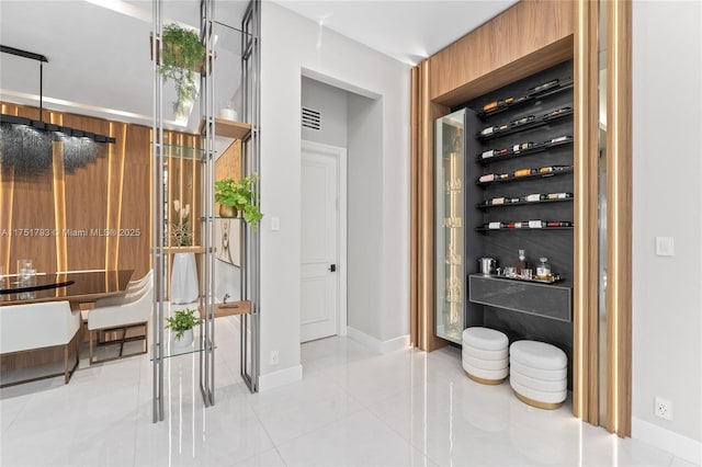 wine room with visible vents, baseboards, and light tile patterned floors