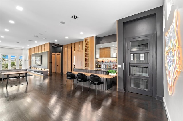 bar featuring baseboards, visible vents, dark wood finished floors, indoor wet bar, and recessed lighting