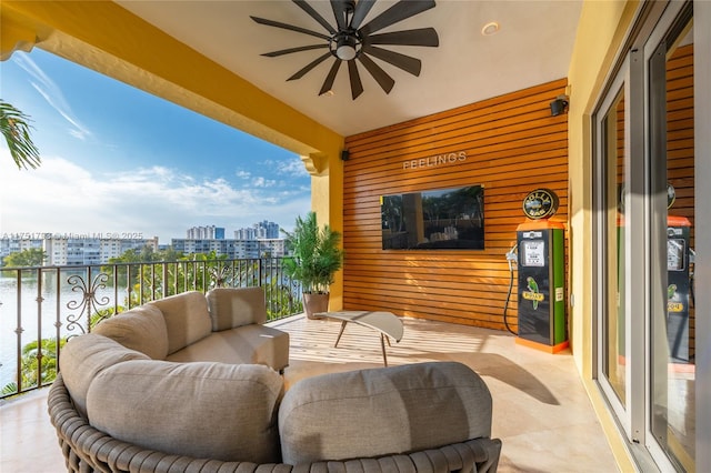 balcony featuring a water view and a ceiling fan