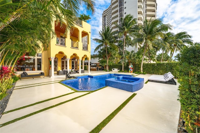 view of pool with a patio and a pool with connected hot tub