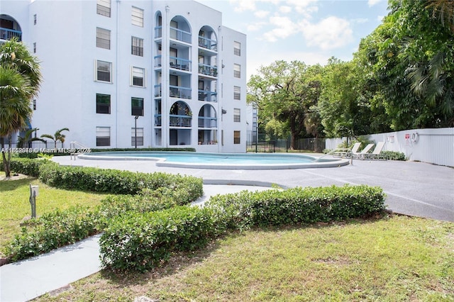 exterior space with a yard, a swimming pool, and fence