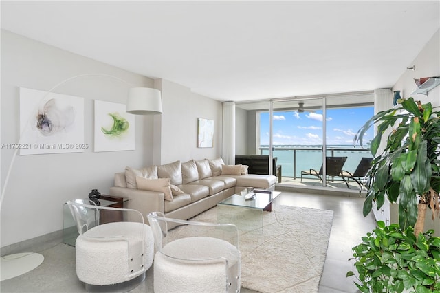 living room with floor to ceiling windows, a water view, and baseboards