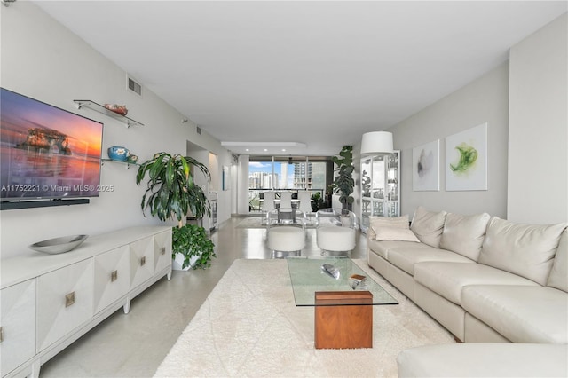 living area featuring finished concrete floors and visible vents