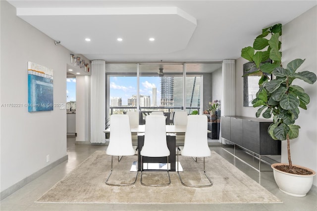 dining space featuring a view of city, concrete floors, baseboards, and recessed lighting