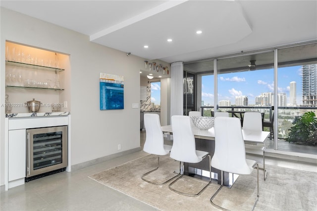 dining room with wine cooler, recessed lighting, baseboards, a view of city, and a dry bar