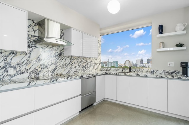 kitchen with light stone counters, a city view, white cabinets, wall chimney range hood, and open shelves