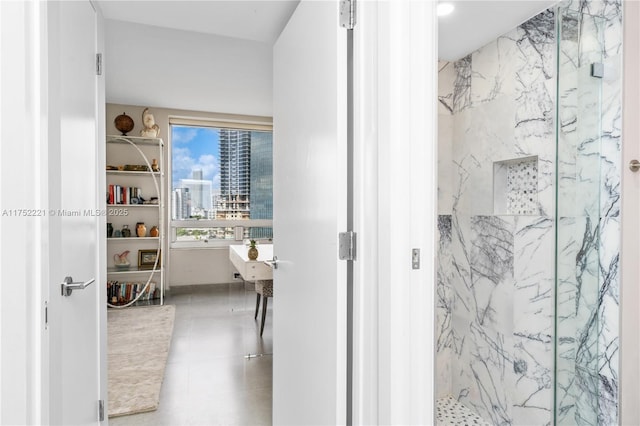 bathroom featuring tile patterned flooring, a city view, and a marble finish shower