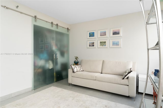 living room with concrete flooring and a barn door