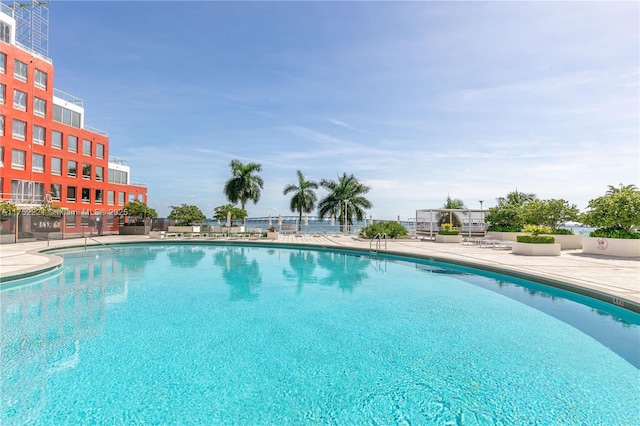 community pool with a patio and fence