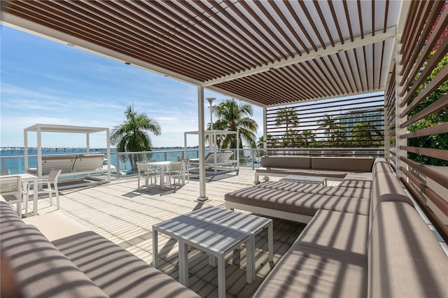 view of patio with a water view, an outdoor living space, and a pergola