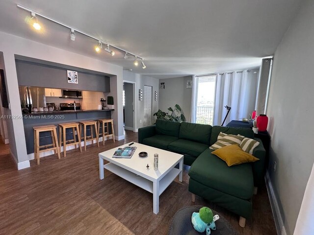 living room featuring wood finished floors and baseboards