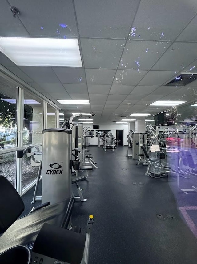 exercise room with a drop ceiling and visible vents