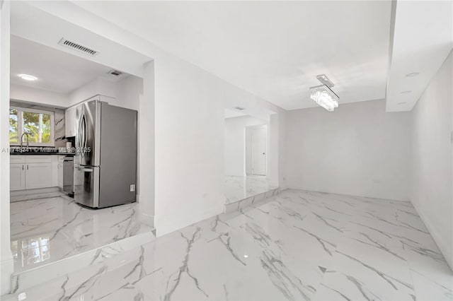 interior space featuring a sink, visible vents, and marble finish floor