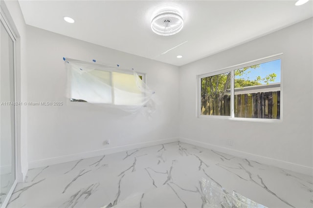 unfurnished room featuring recessed lighting, marble finish floor, and baseboards