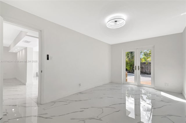 empty room featuring visible vents, french doors, marble finish floor, and baseboards