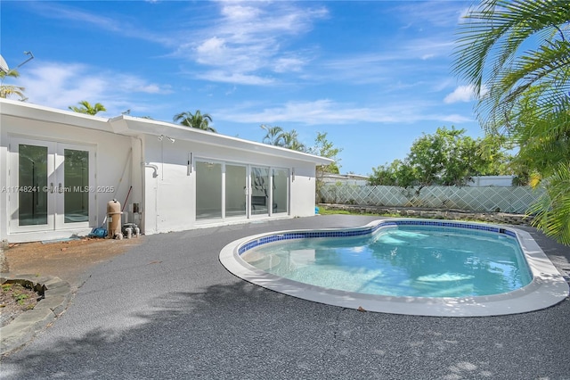 view of pool featuring french doors, a patio, a fenced in pool, and fence