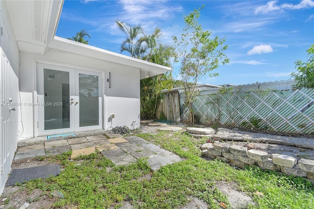 view of yard with french doors and fence